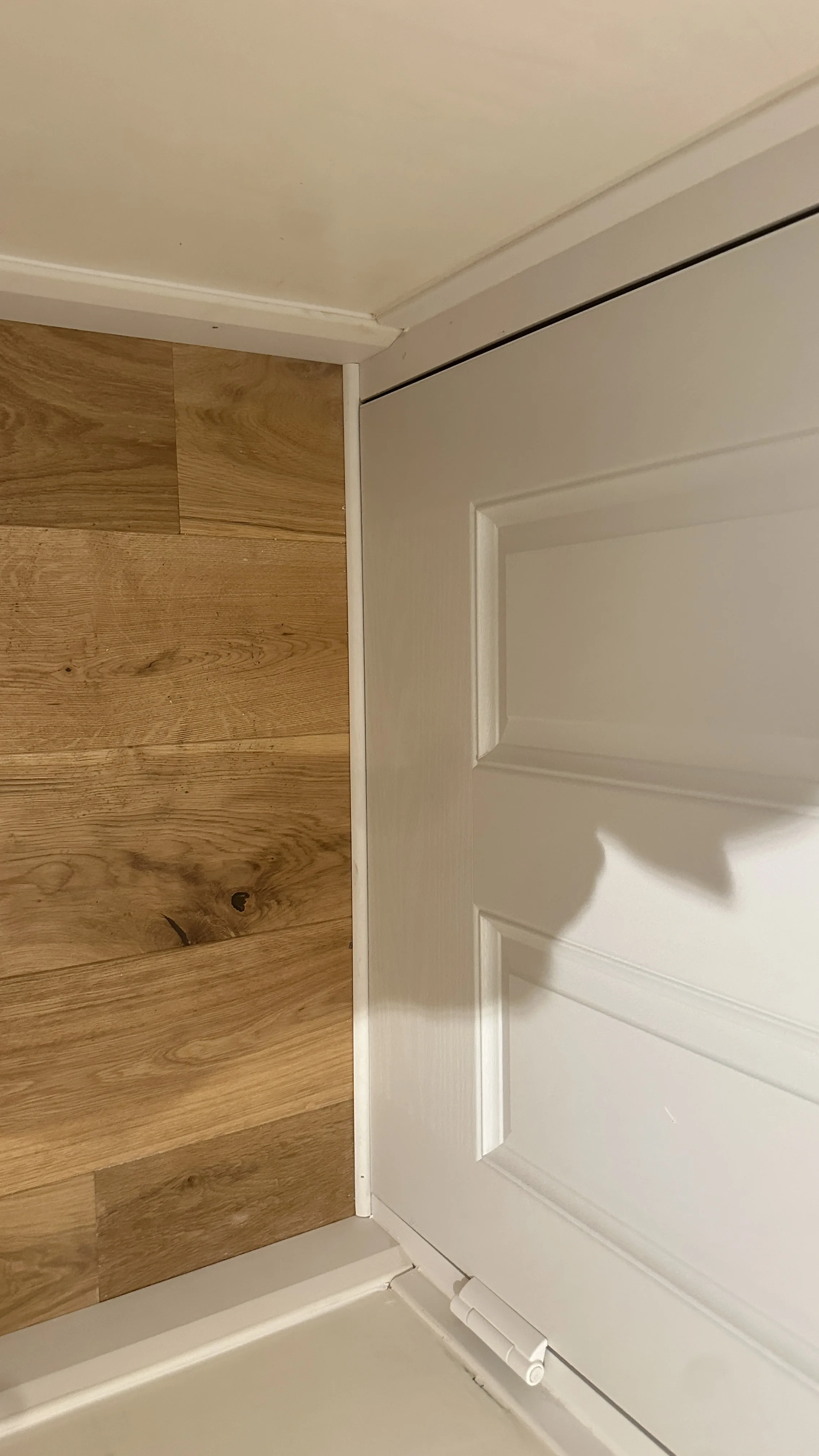 Flooring Installation project in Bicester - a white door with a wooden paneled wall